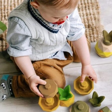 Pineapple-shaped silicone stacking toy for babies and toddlers with soft, rounded pieces.